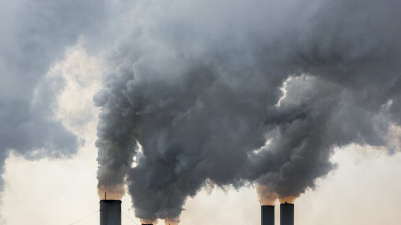 Plumes of smoke rise from chimneys at an industrial area