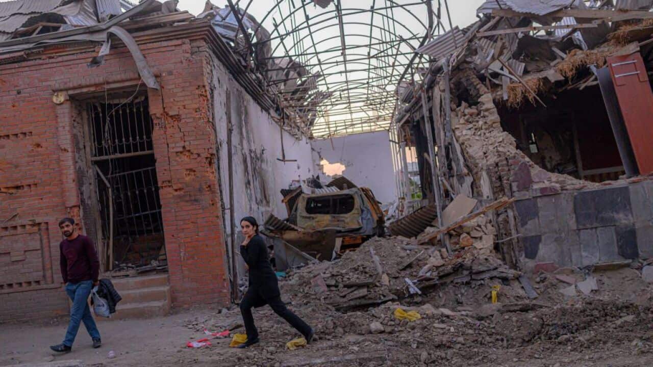 Local residents walk in a street after it was hit by a missile in Gandja, Azerbaijan, on October 8, 2020