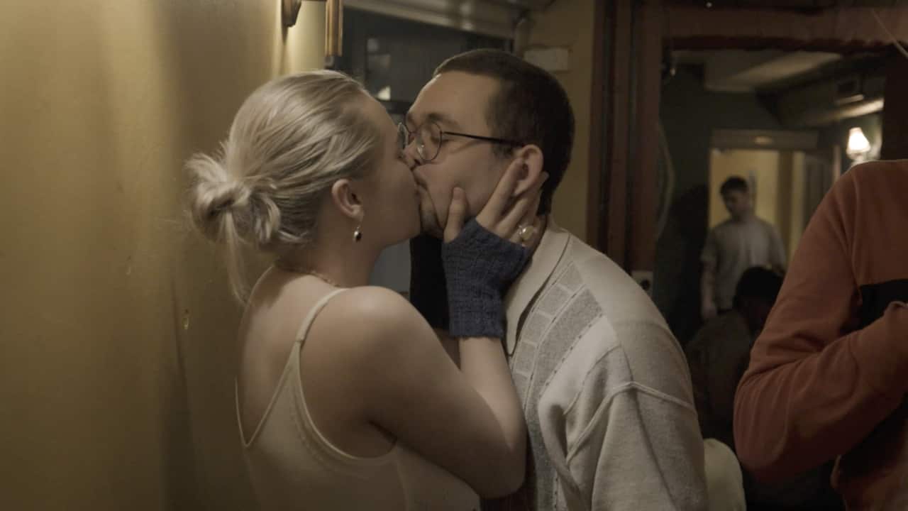 Two people kiss in a Denmark pub.