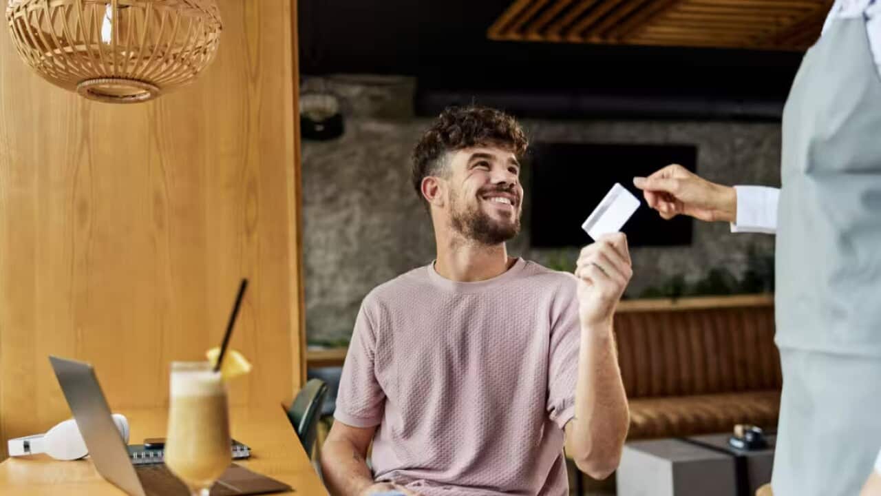 Man paying the bill with his credit card to the waitress in a café. Credit: skynesher/Getty Images