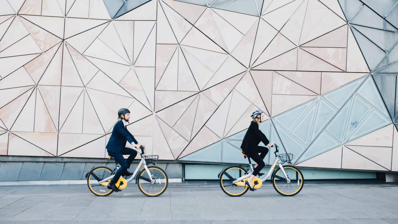 Cyclists on Melbourne’s Obikes next to Federation square