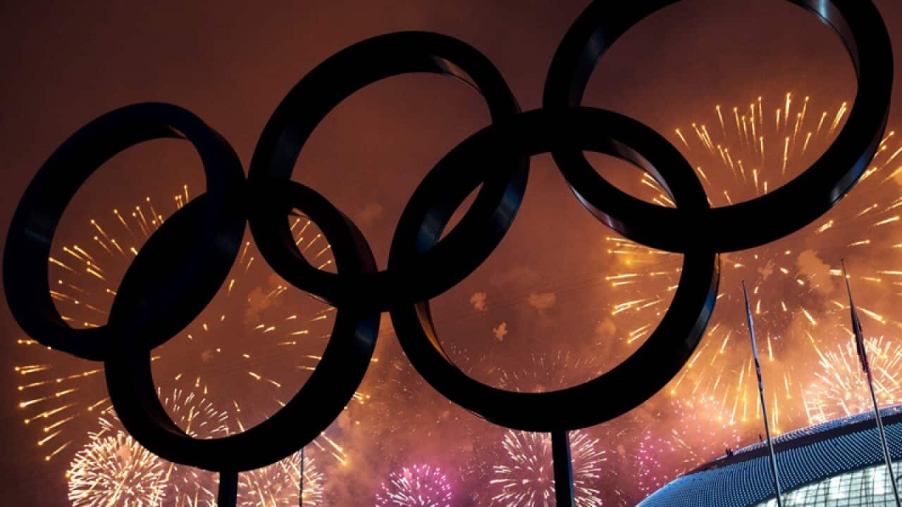 The Olympics Rings are silhouetted as fireworks light the sky