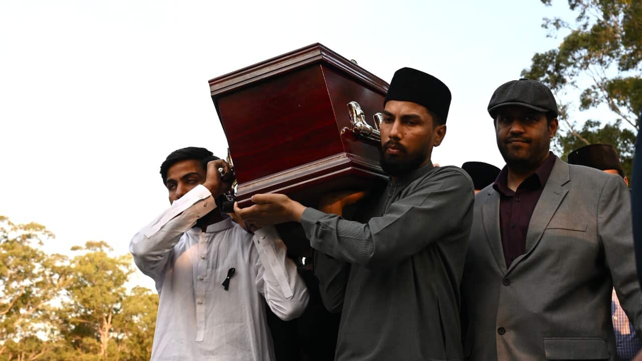 People carry a casket on their shoulders