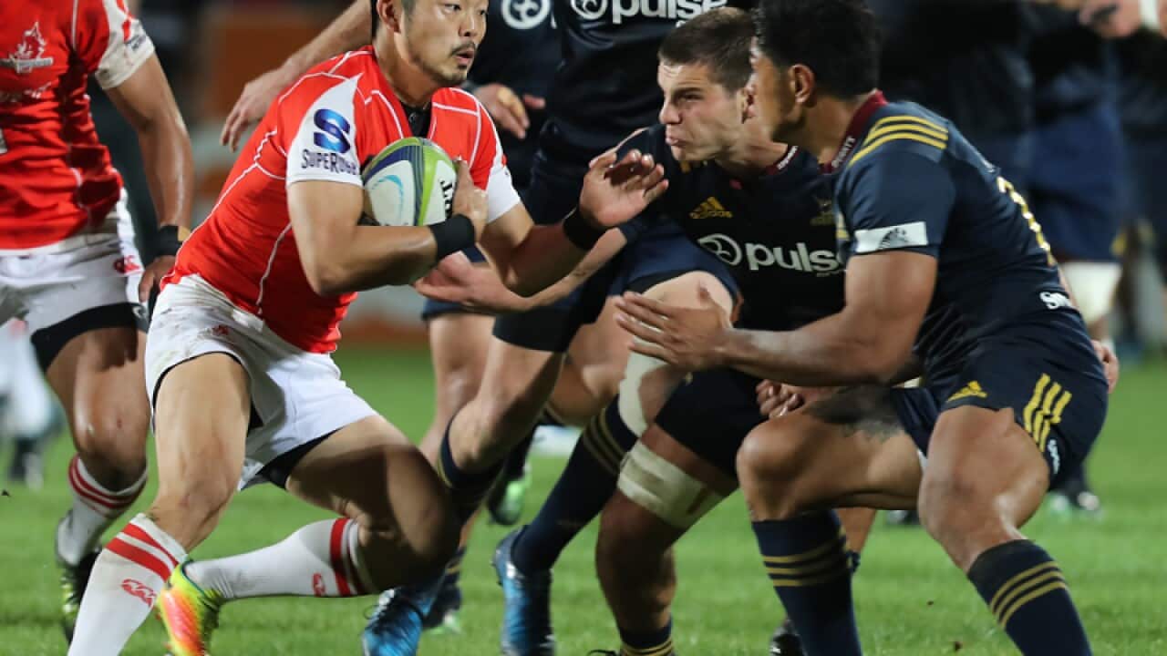 Yasutaka Sasakura of the Sunwolves, centre, makes a run