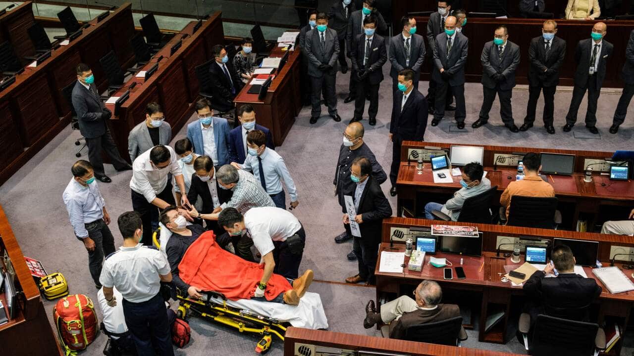 Pan-democratic legislator Andrew Wan Siu-kin is taken away after scuffles during a Legislative Council House Committee meeting, in Hong Kong on 8 May.