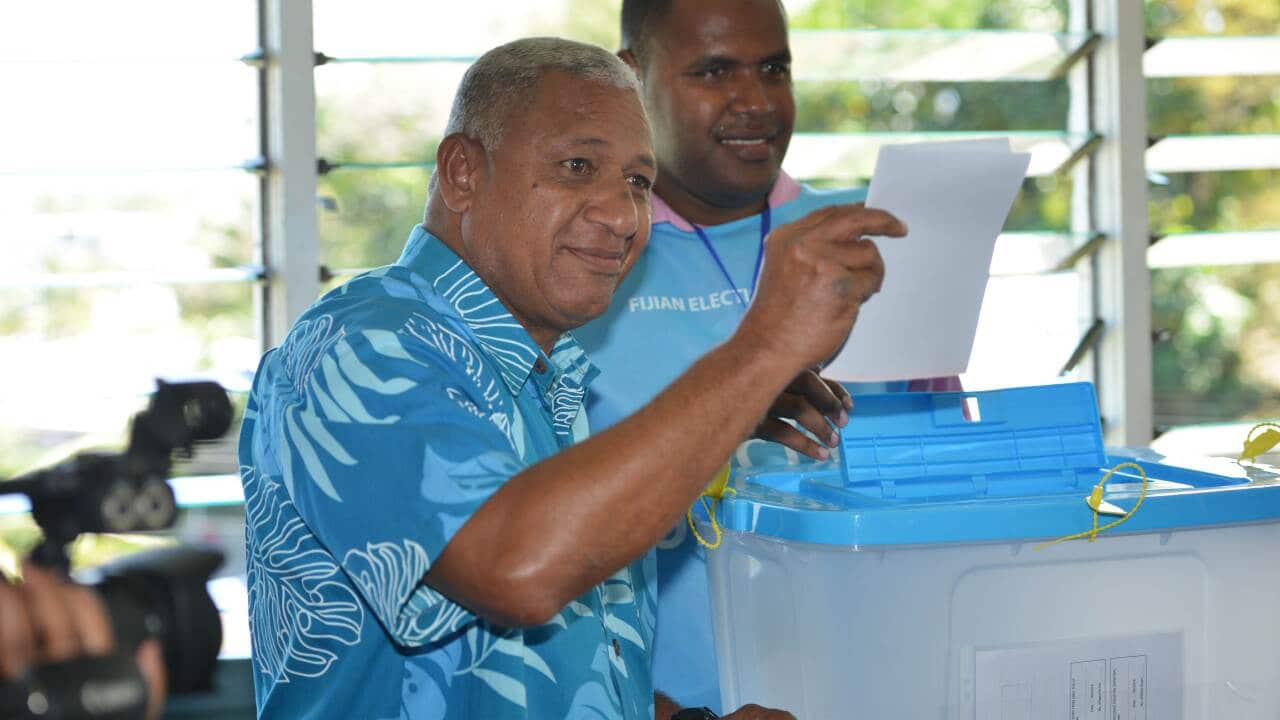 Fiji's military strongman Voreqe Bainimarama (L) prepares to cast his election vote at the Vatuwaqa Public School in the capital Suva on September 17, 2014. (AAP)