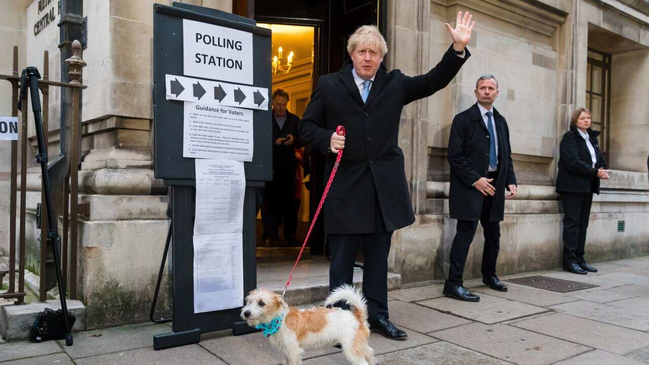 Britain's Prime Minster Boris Johnson (C) leaves a polling station after casting his vote
