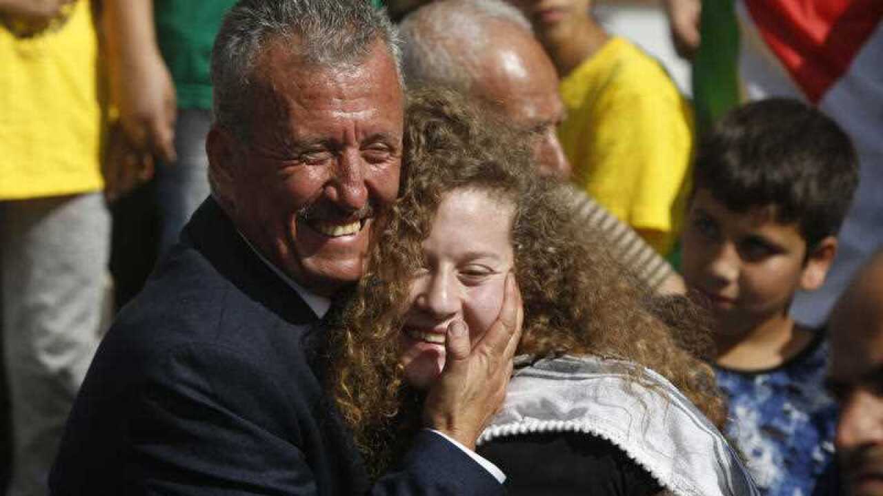 Ahed Tamimi is hugged by her father Bassam during a press conference