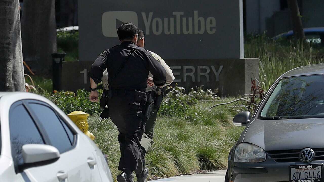 Officers run toward a YouTube office in San Bruno, Calif., Tuesday, April 3, 2018.