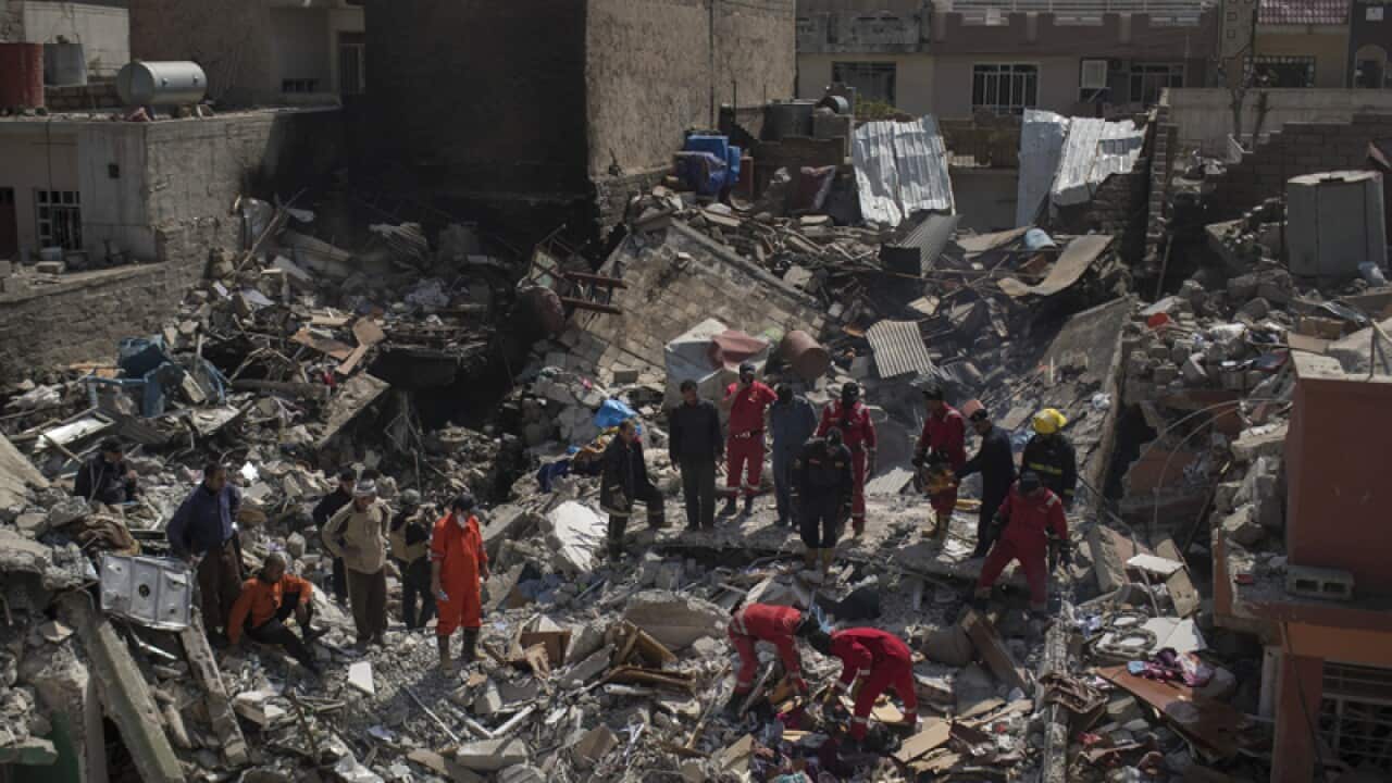 Rescue teams work on the debris of a destroyed house in Mosul