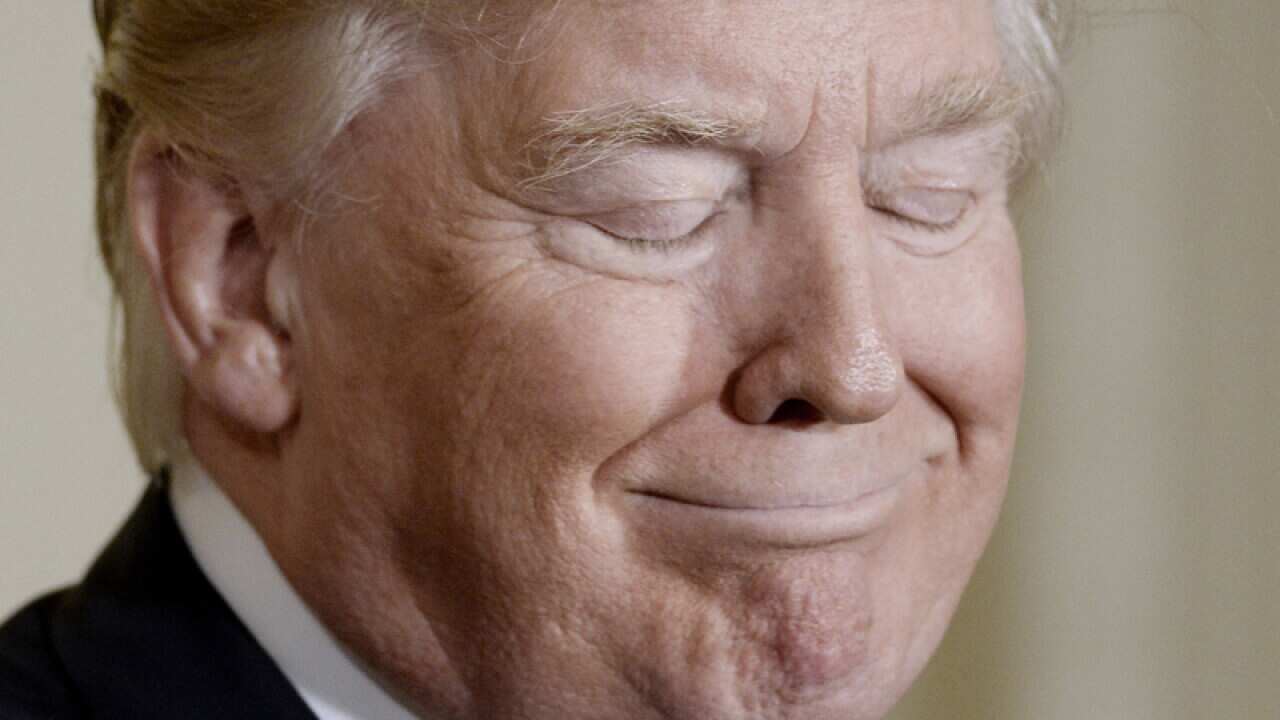President Donald Trump looks on in the East Room of the White House