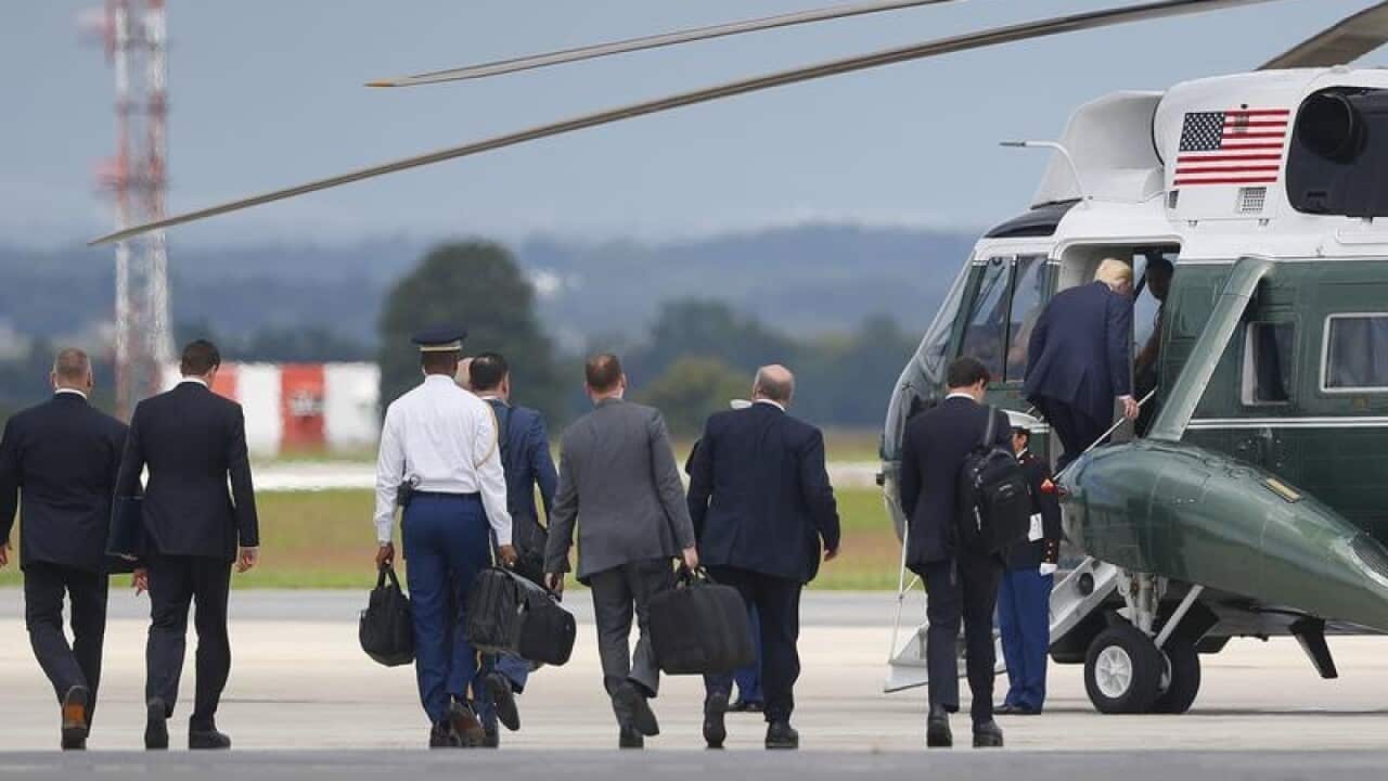 President Donald Trump, right, boards Marine One helicopter