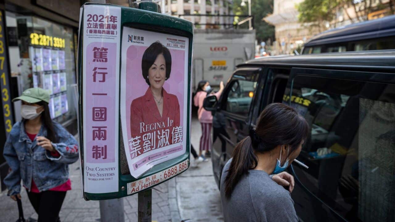 A poster for a candidate for the legislative elections is taped to a bus stop in Hong Kong