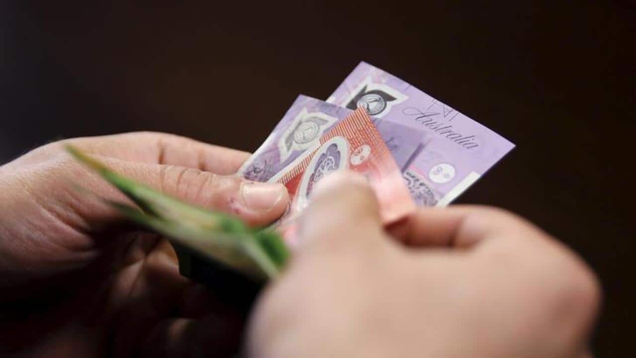 An employee counts Australian dollar banknotes at an exchange office in downtown Cairo