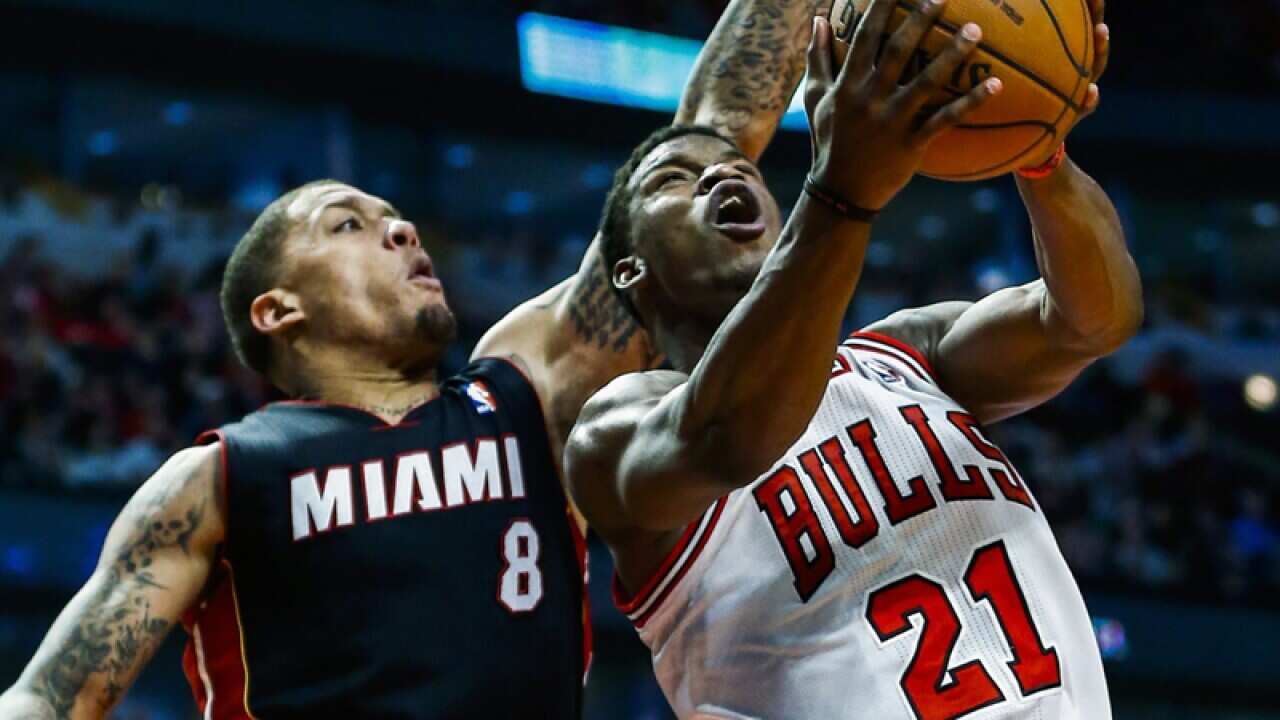 Chicago Bulls guard Jimmy Butler (R) shoots the ball