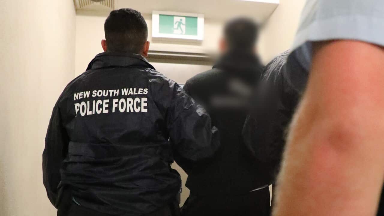 A man is led into a police station by police