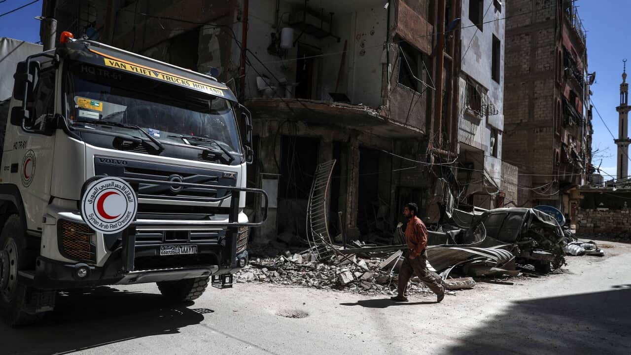 Aid trucks drive through a destroyed neighbourhood in rebel-held Douma.