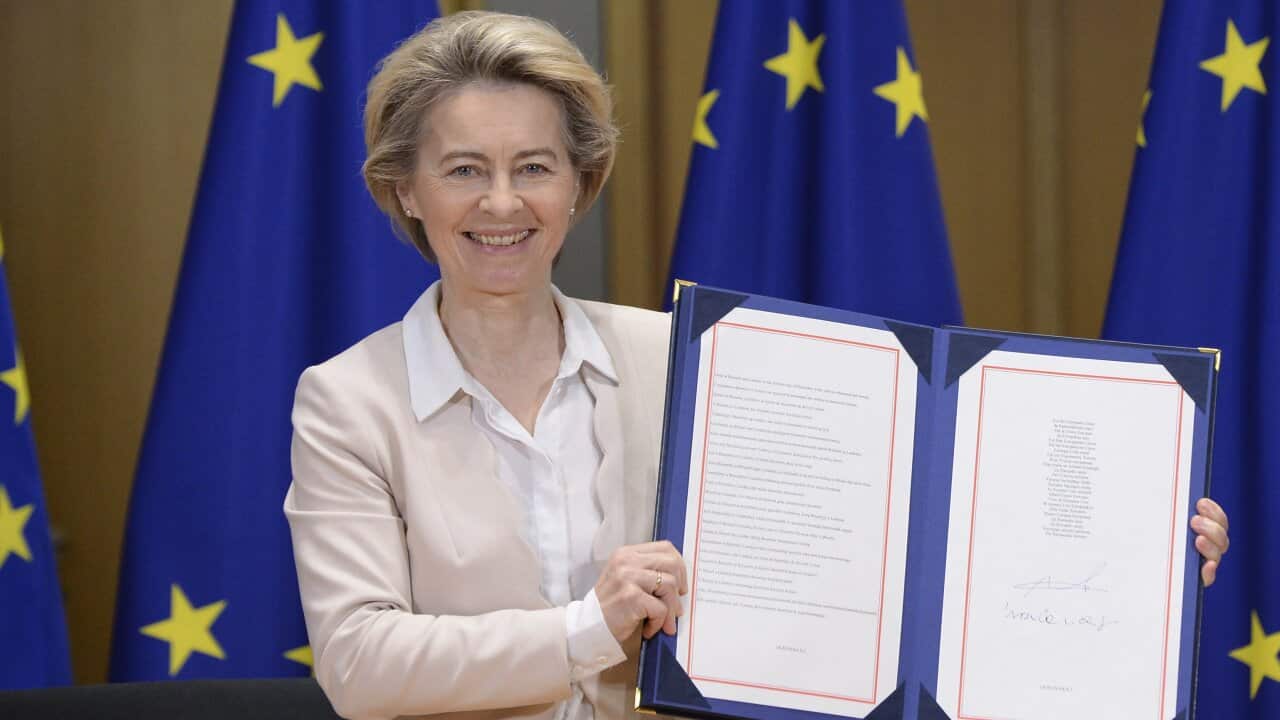 European Commission President Ursula von der Leyen shows the signed agreement in Brussels on Wednesday.
