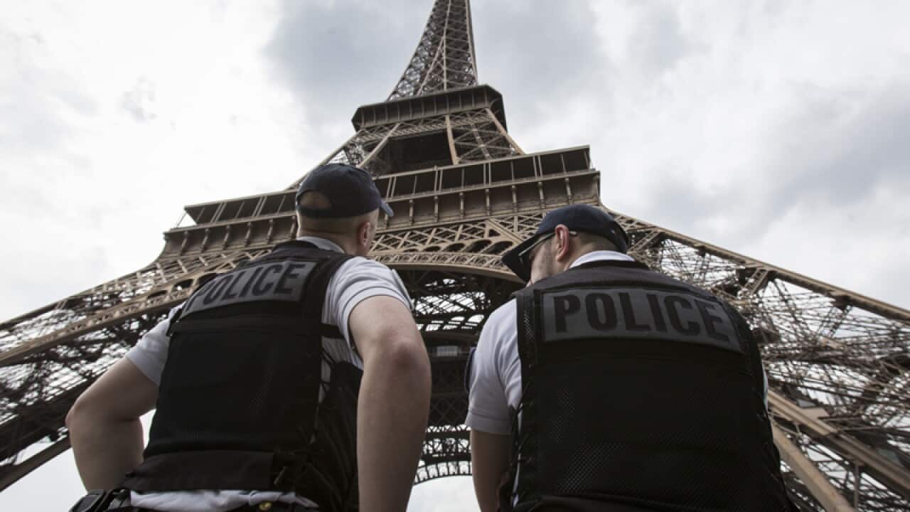 Police officers in front of the Eiffel Tower