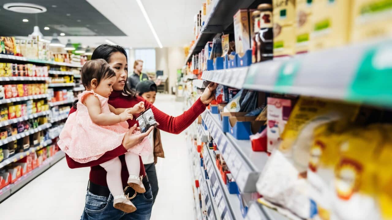Mother Holding Daughter While Shopping