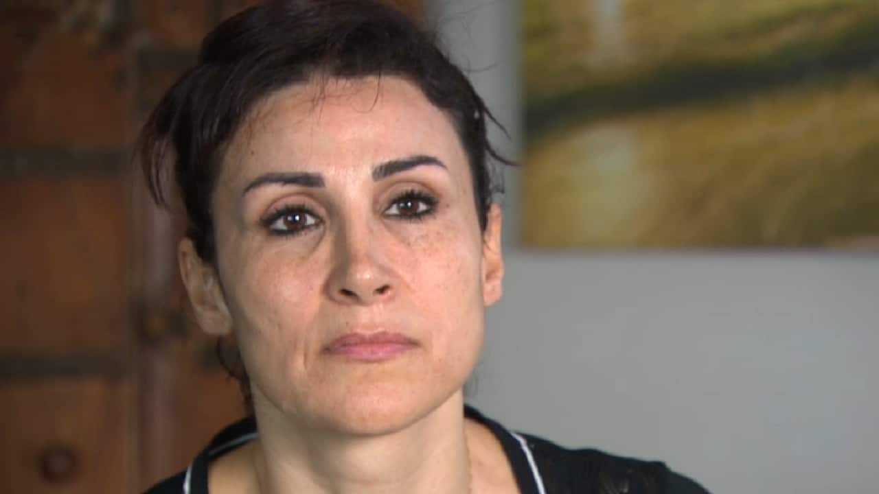 Syrian-Australian woman looks at camera.