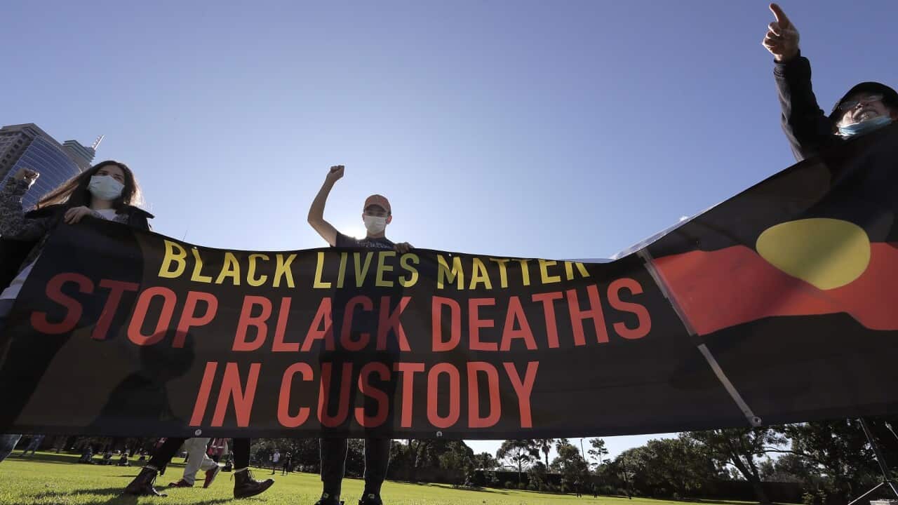 Supporters hold a banner protesting about Black Deaths in Custody at a rally in Sydney on July 5, 2020