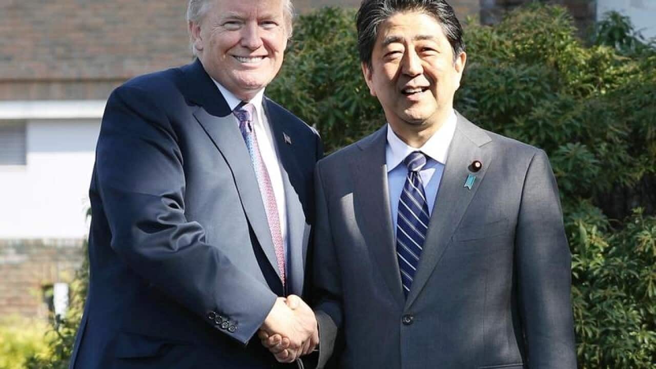 Donald Trump shaking hands with Shinzo Abe