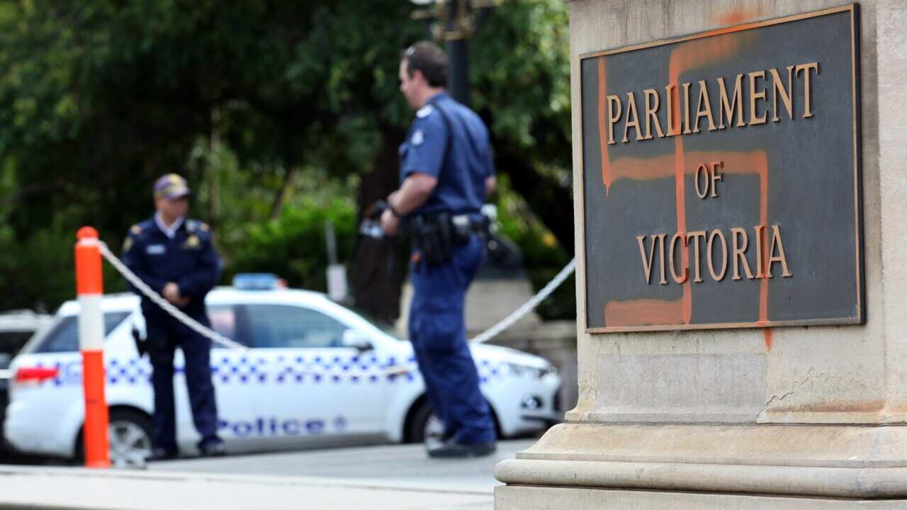 Police inspect graffiti on the front of the Victorian State Parliament, in 2012