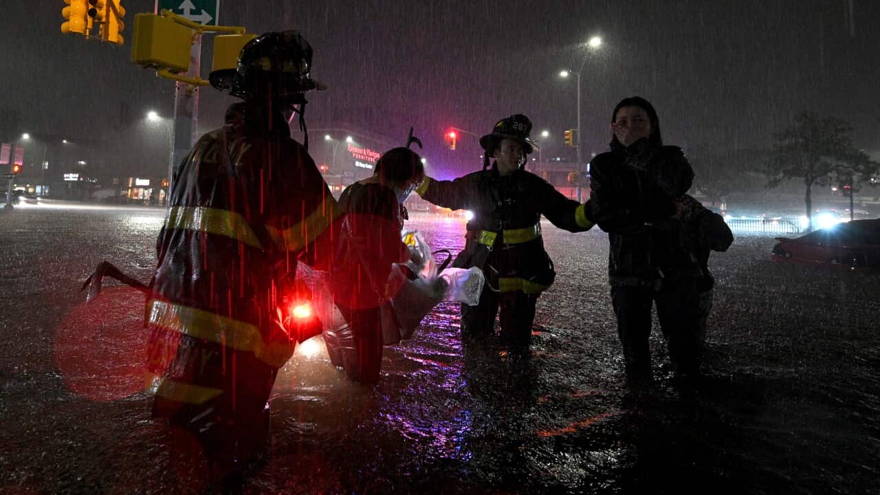 Members of the FDNY rescue a woman from her car stalled due to flash flooding after remnants of Hurricane Ida in the New York City, 1 September, 2021.