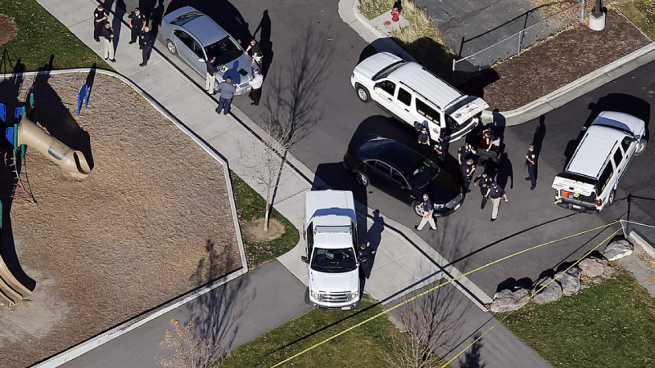 Officials investigate the scene of a shooting in Sandy