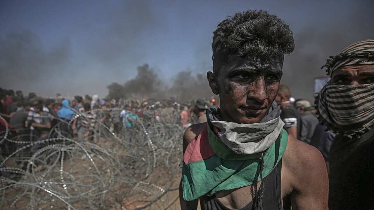 Palestinians protesters pulling barbed wire fence installed by Israeli army along the border during clashes after protests near the border with Israel