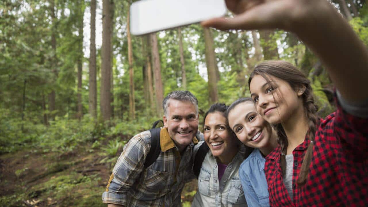 Family hiking taking selfie in woods