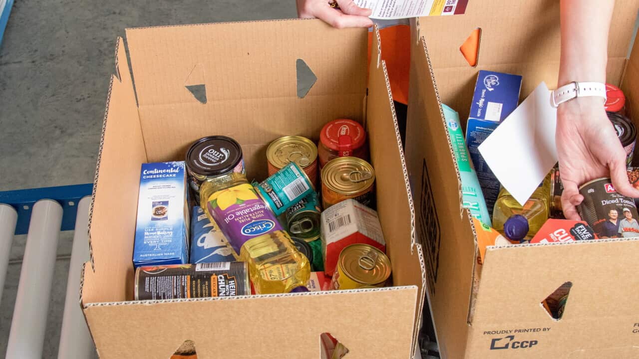 Two cardboard boxes filled with cans and jars of food.