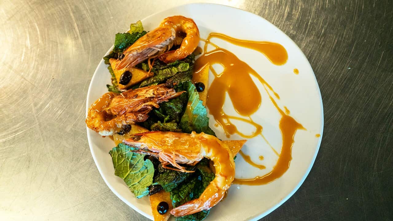 Gamberi e polenta crostino (King prawns, polenta fritters with red mustard leaves and black garlic)