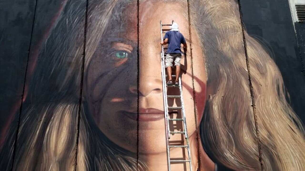 Italian Artist Jorit painting a portrait of Ahed Tamimi