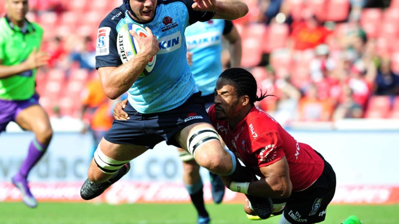 Dean Mumm (L) of the Waratahs is tackled by Lions' Courtnall Skosan