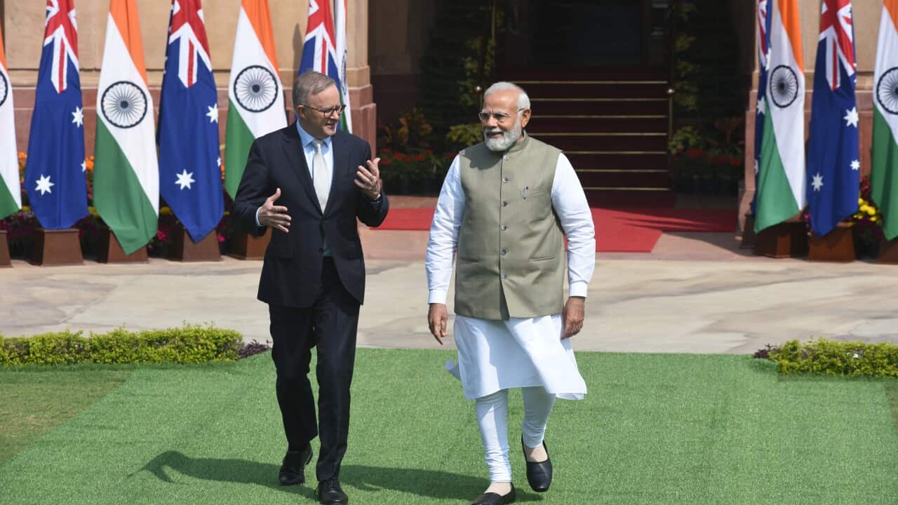 Prime Minister Anthony Albanese with his Indian counterpart Narendra Modi in front of a line of Indian and Australian flags.
