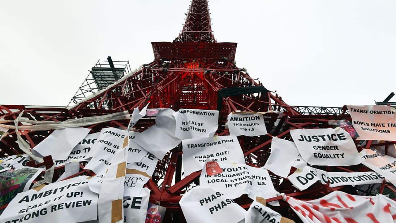 An Eiffel Tower made of bistro chairs is seen covered in messages related to climate change