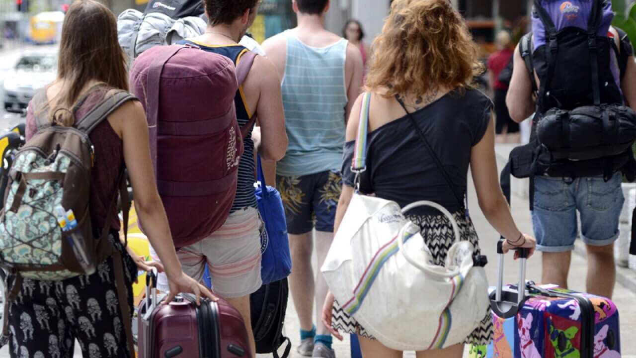 Backpackers walk through the streets of Brisbane