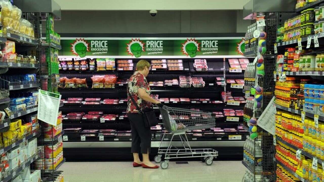 A shopper looks at the meat section inside a Woolworths grocery store.