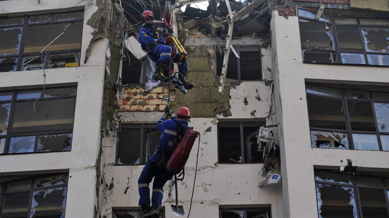 Rescuers work near a damaged residential building, which was damaged as a result of a missile strike by the Russian army.