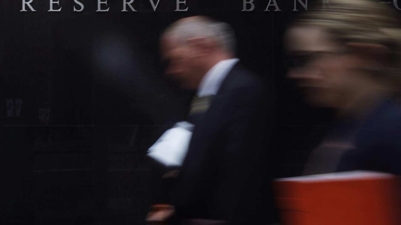 Pedestians walk past the Reserve Bank