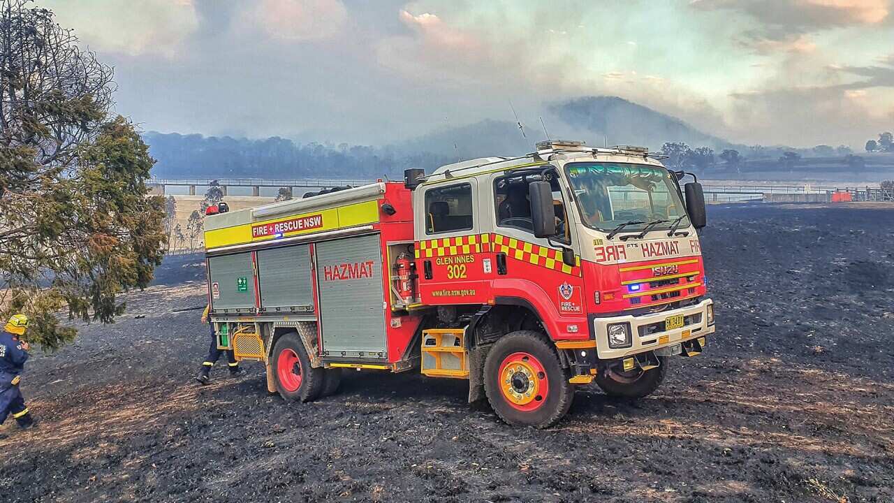 Firefighters from Fire and Rescue NSW, Station 302 Glen Innes assist in the fight against a bushfire in Tenterfield.