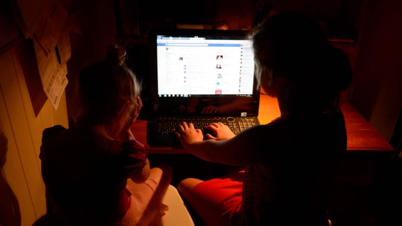 Young girls use a personal computer in Brisbane, Wednesday, Oct. 16, 2013. (AAP Image/Dan Peled) NO ARCHIVING
