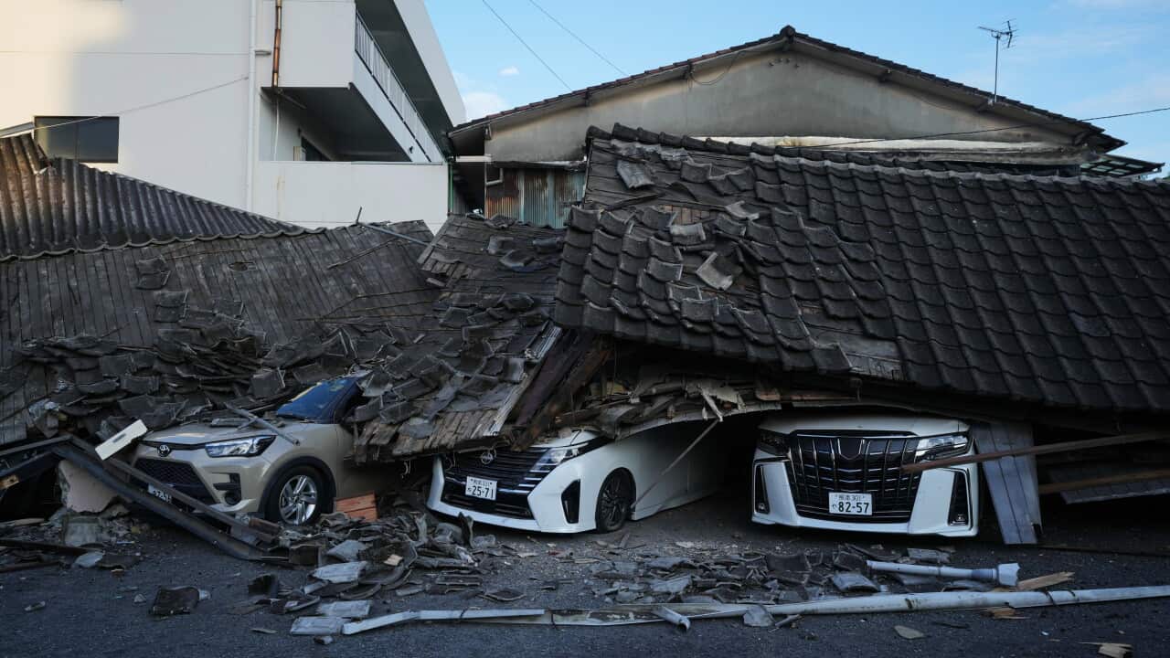 Three cars crushed underneath a collapsed roof.