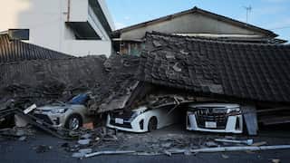 Three cars crushed underneath a collapsed roof.