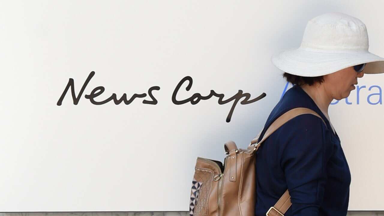 A women passes by the News Corp Australia signage, Sydney