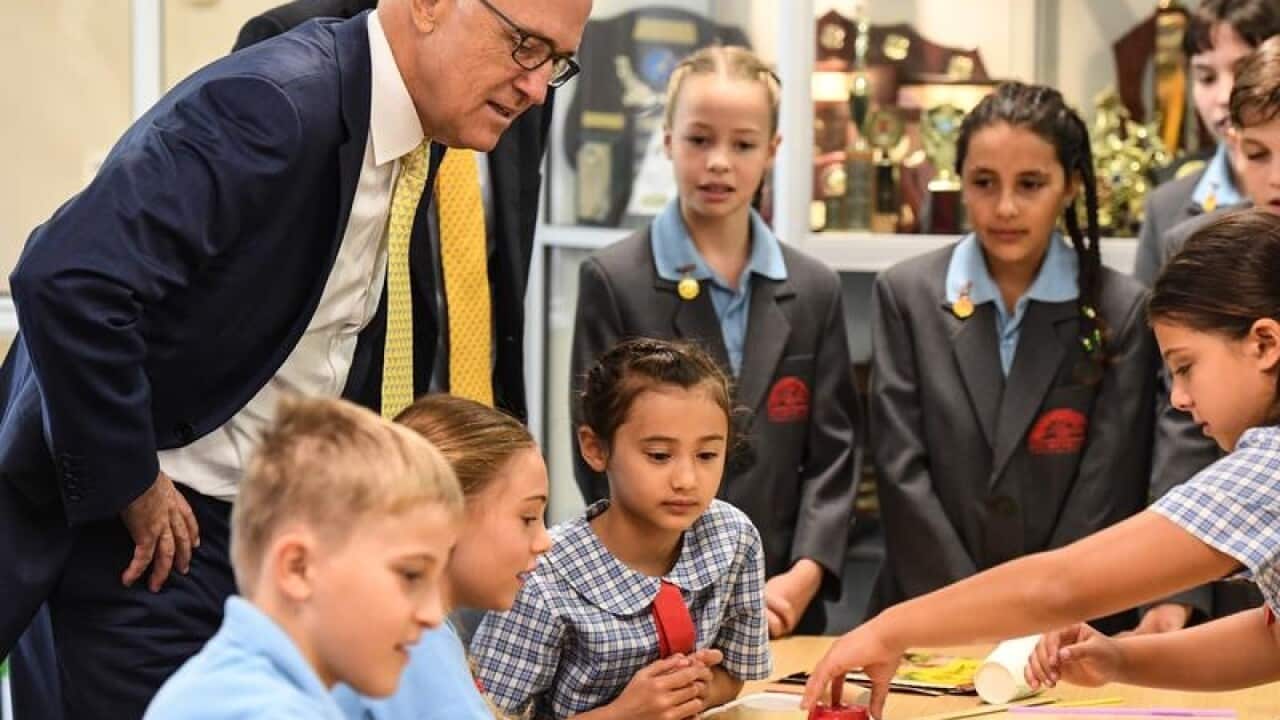 Prime Minister Malcolm Turnbull looks over school students.