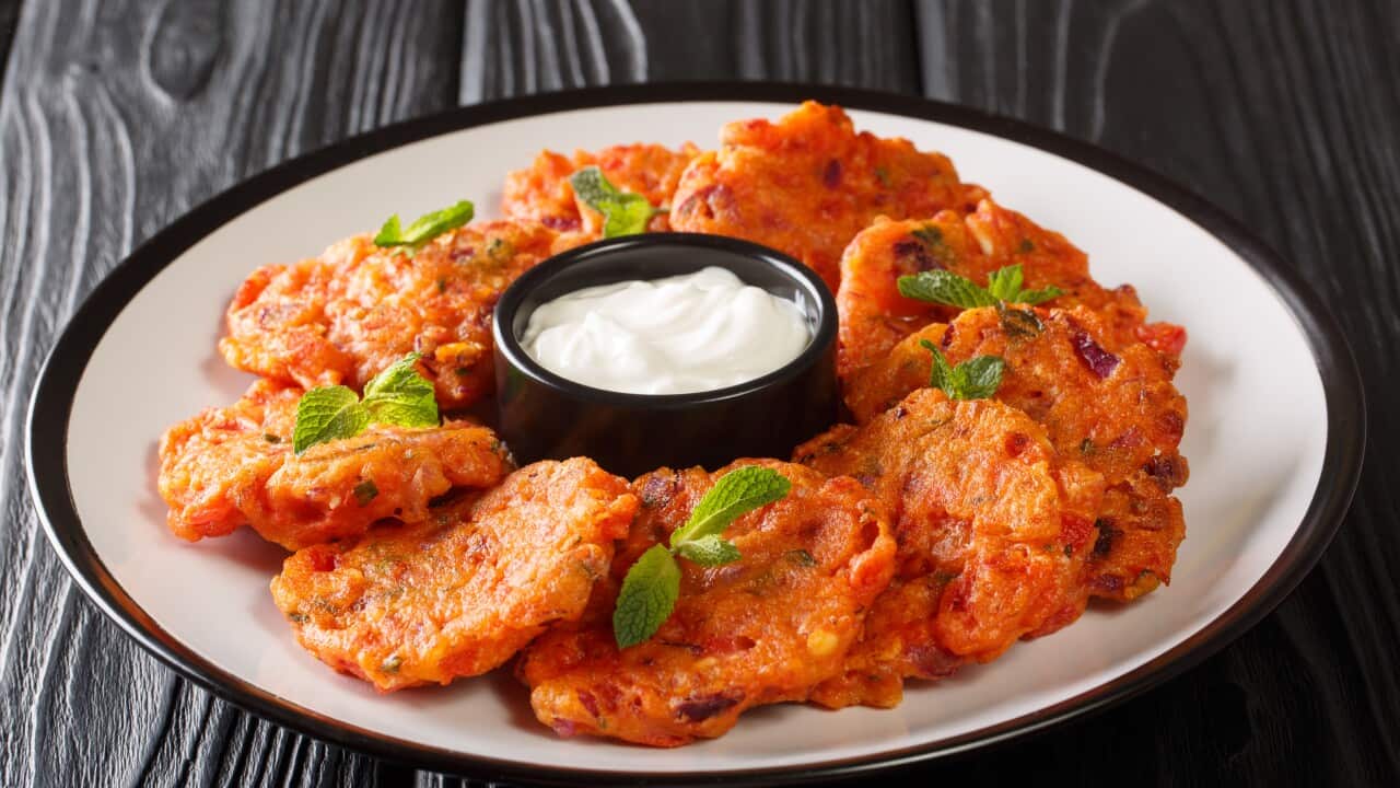 Delicious Greek tomato fritters with feta and mint served with yogurt close up in a dish. horizontal