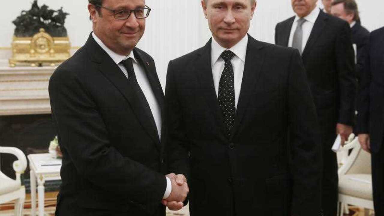 Russian President Vladimir Putin and French President Francois Hollande, left, shake hands during their meeting in the Kremlin in Moscow, Russia, Thursday, Nov. 26, 2015.